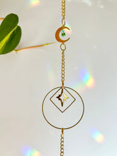 Load image into Gallery viewer, Gold Charm Suncatcher with Moon, Starburst, Round &amp; Diamond Shapes, Green &amp; Blue Glass Beads – Rainbow Prism Window Decor
