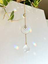 Load image into Gallery viewer, Gold Charm Suncatcher with Moon, Starburst, Round &amp; Diamond Shapes, Green &amp; Blue Glass Beads – Rainbow Prism Window Decor

