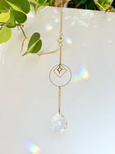 Load image into Gallery viewer, Gold Charm Suncatcher with Moon, Starburst, Round &amp; Diamond Shapes, Green &amp; Blue Glass Beads – Rainbow Prism Window Decor
