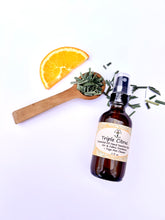 Load image into Gallery viewer, Citrus essential oil spray next to yoga props and meditation tools
