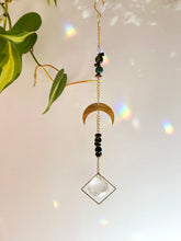 Load image into Gallery viewer, Prism detail on half moon suncatcher scattering rainbow light across wall
