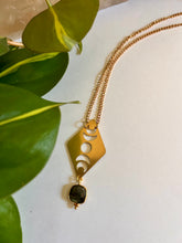 Load image into Gallery viewer, Moon phases gold necklace with labradorite gemstone shown in a flat lay celestial style
